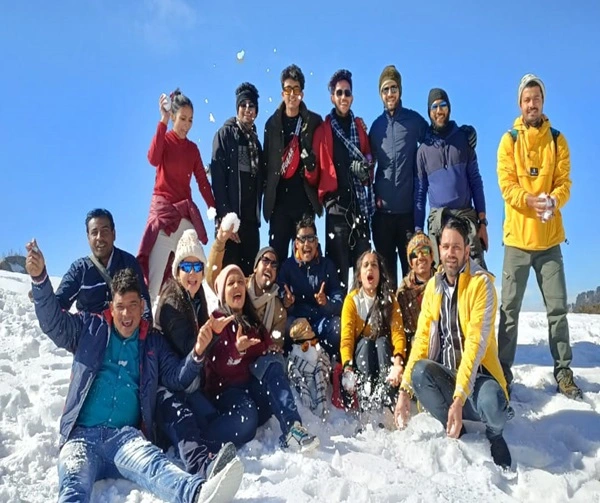 a group of people playing with snow at lake glacier trek which is the best winter trek in india