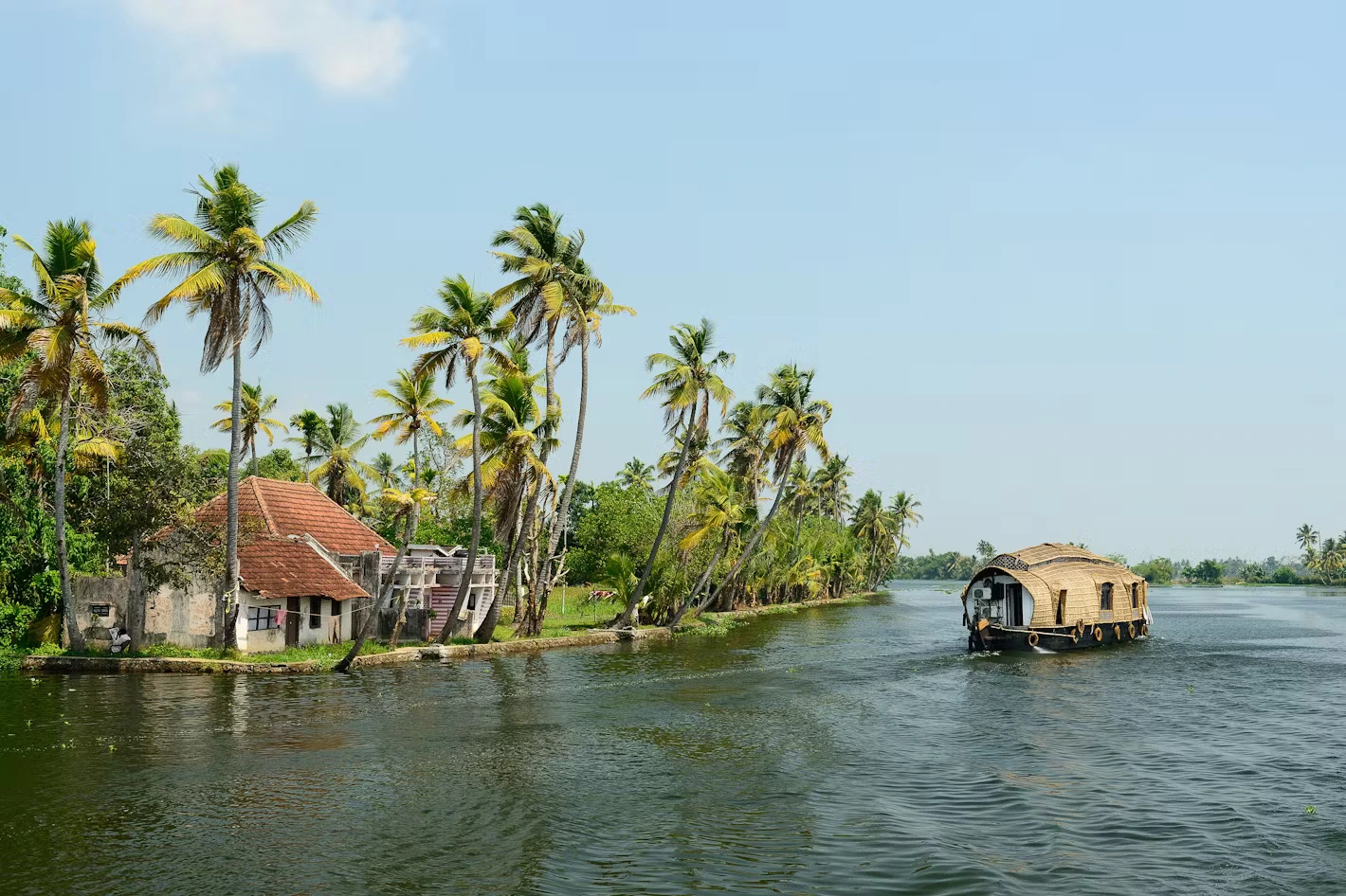 View of Kerala Backwaters with houseboat floating into it, best place to visit in India for honeymoon.