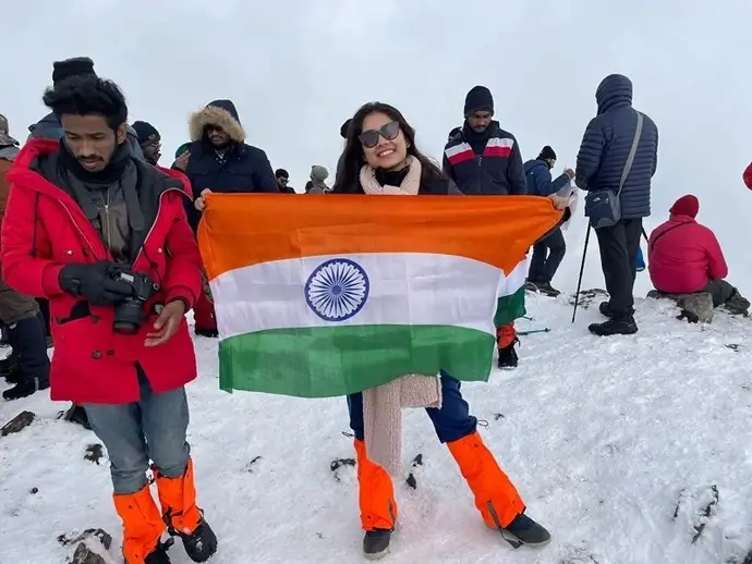 Delighted trekker posing with indian national flag from the summit of Brahmatal trek after the completion of trek.